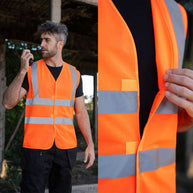 Warnweste Minden aus leuchtend orangefarbenem Polyester mit vier breiten, silbernen Reflexstreifen und praktischem Klettverschluss.