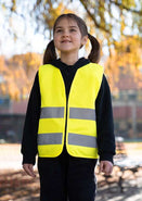 Kind wearing bright yellow Korntex Reißverschluss-Warnweste for children with reflective strips outdoors